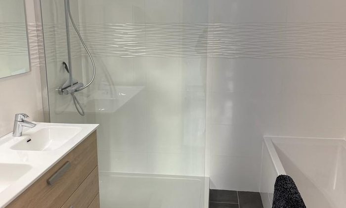 Salle de bain rénovée avec douche, vasque et WC